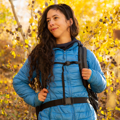 smiling woman wearing the aspen backpack on trail